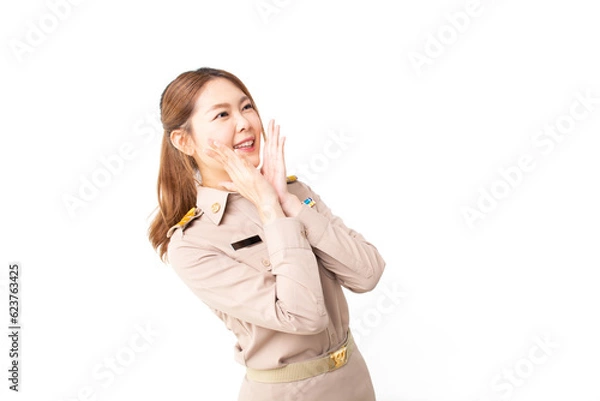 Obraz Female Thai government officer in khaki uniforms looking copy space in excitement on white background. Surprised Asian woman act like a telling secret. facial expressions. Presenting some product.