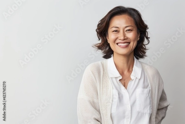 Obraz Portrait of a smiling asian businesswoman standing against white background