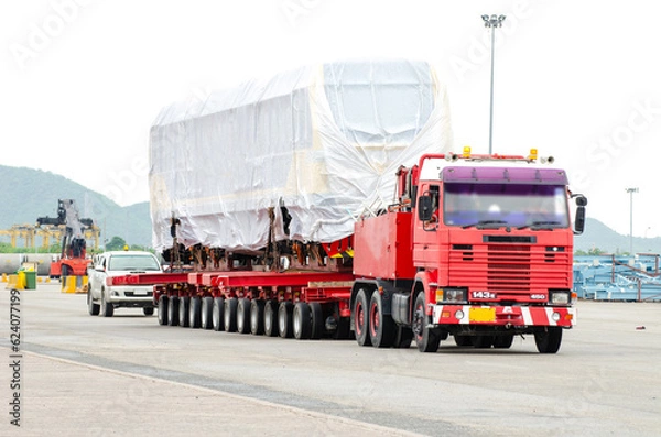 Obraz Transport of Oversize Heavy Machinery cargo truck Loading a new locomotive port area