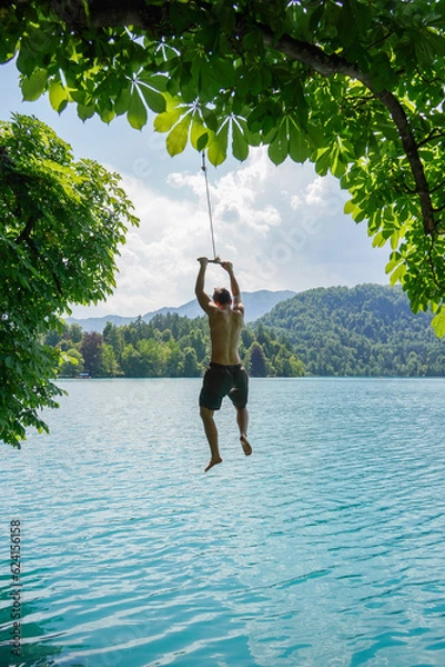Obraz Person jumping in the crystal clear water of lake bled