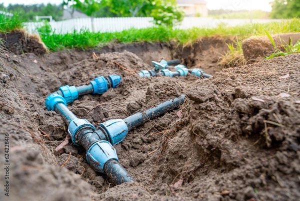 Fototapeta Plastic pipes and circuit wiring for lawn irrigation. Connection fittings and valves for shutting off water in the garden