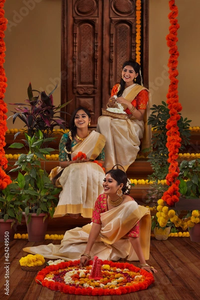 Fototapeta Women decorating floor with flowers on the occasion of Onam
