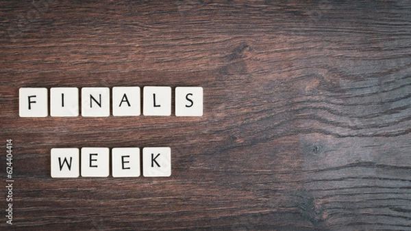 Fototapeta Back to school concept. Finals week word on wooden desk.