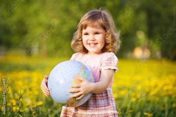 Fototapeta Little smiling girl with a globe in a summer field