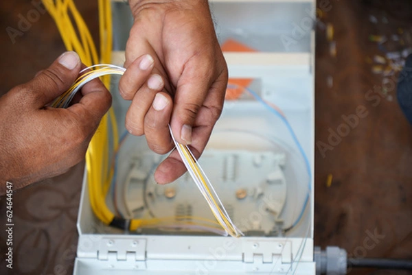 Obraz hands installing fiber cable Optical in junction box