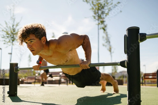 Obraz Strong young sportsman doing calisthenics