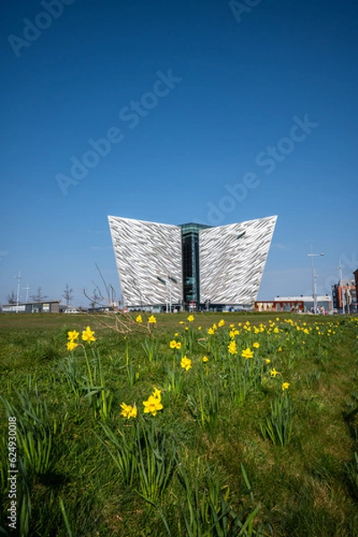 Fototapeta The Beautiful Exterior of the Titanic Museum in Titanic Quarter with beautiful yellow tiny flowers view in its front