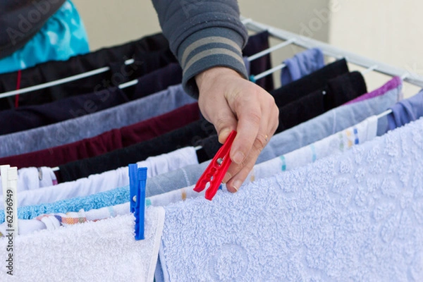 Obraz Young man drying clothes after laundry