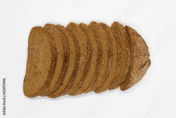Fototapeta Sliced black bread. Dark rye bread with cumin cut into even pieces on a white background. Wheat black bread on the table. Isolated. Bran from grain. Healthy food. Vegetarian food. Ecological friendly