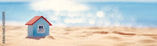 Obraz Miniaturowy model domu stojącego na piasku na Seacoast.