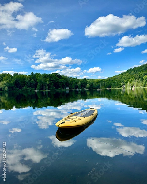Fototapeta A standup paddle board floats on a  lake.