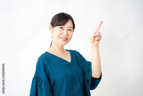 Fototapeta 右側を指差すミドルエイジの女性　白背景