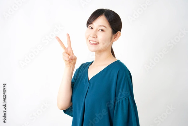 Fototapeta ピースサインするミドルエイジの女性　白背景