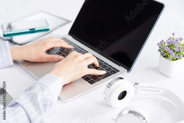 Obraz ノートパソコンを使ってデスクワークをするビジネスウーマン　顔無し