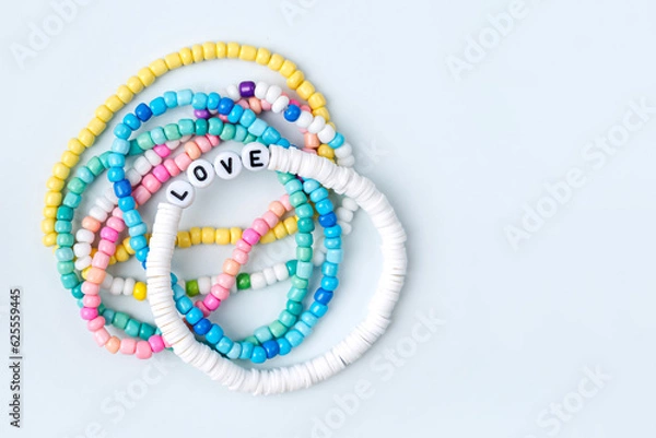 Fototapeta Kids handmade beaded jewelry. Necklaces and bracelets made from multicolored beads and pearls. DIY bracelet beads. Children's needlework. Creativity and hobby. Art activity for kids