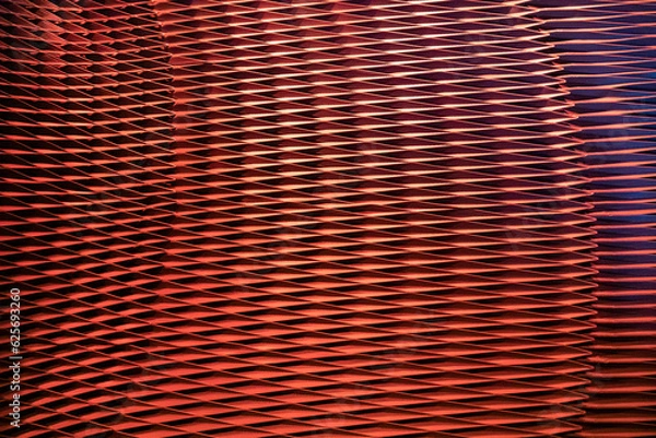 Fototapeta View to metal mesh facade, abstract background in red colour. 