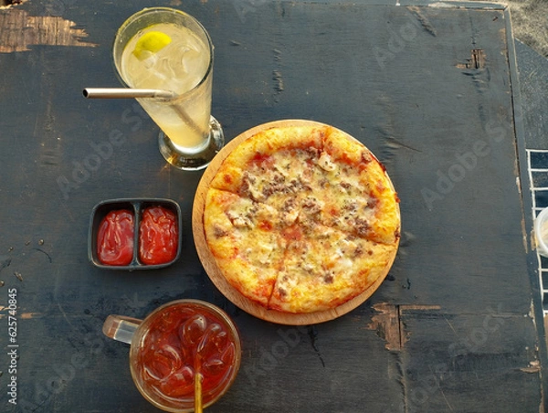 Obraz Portrait of delicious pizza, cold drinks, and fresh tomato sauce Tempting at the Table