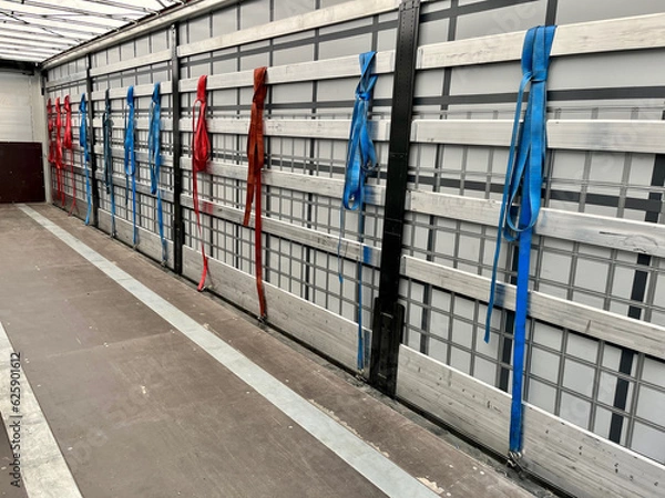 Fototapeta View inside the semi-trailer. Tie straps for securing loads hang on the side aluminum boards