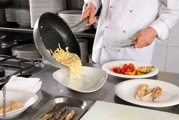 Obraz Chef preparing pasta on professional kitchen in restaurant