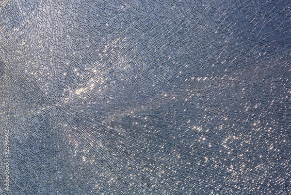 Fototapeta cracks at tempered glass, spoiled glass surface, texture background, blind windscreen close-up, nobody.