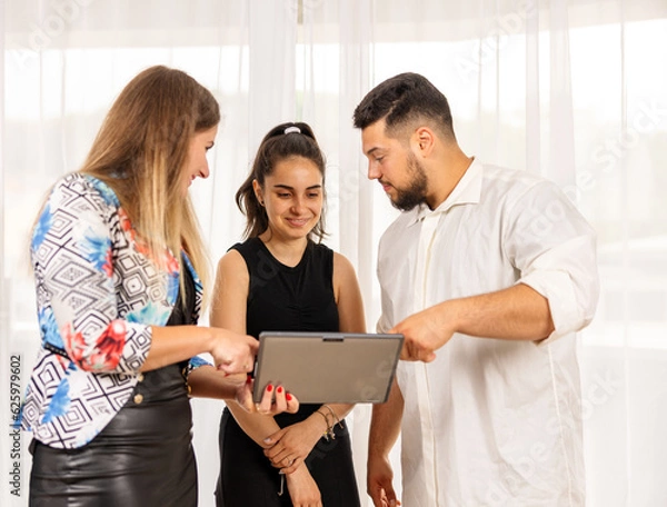 Fototapeta Team working together looking at a tablet