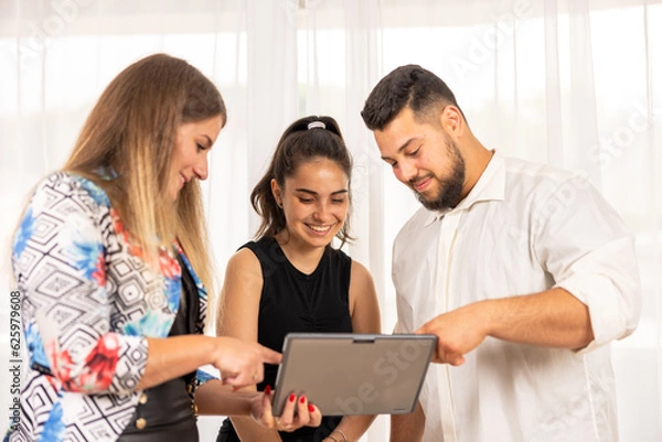 Fototapeta Team working together looking at a tablet
