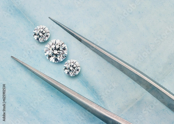 Obraz 3 Round Diamonds. 3 Stone Diamond Photograph on Blue Background with Diamond Tweezers. Graduated Set of Diamonds.