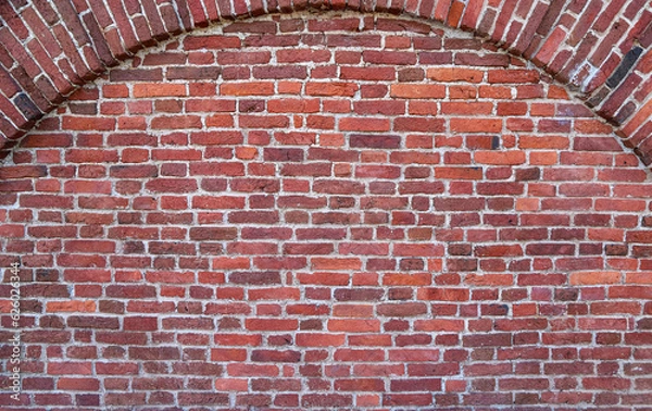 Fototapeta Texture of an old red brick wall with the semicircular arch in brickwork as an old-fashioned architectural background