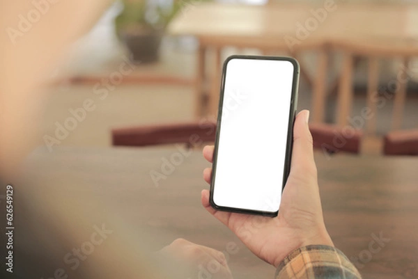 Fototapeta cell phone blank white screen mockup.hand holding texting using mobile on desk at office.background empty space for advertise.work people contact marketing business,technology