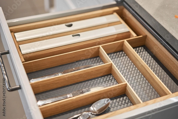 Fototapeta Kitchen utensil cutlery drawer organizer tray with simple set of tools, minimalist order. Open drawer with different utensils and folded towels. Order in kitchen. Kitchen furniture store.