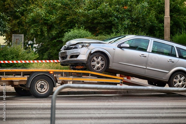 Fototapeta Samochód pomocy drogowej wiezie uszkodzony pojazd.