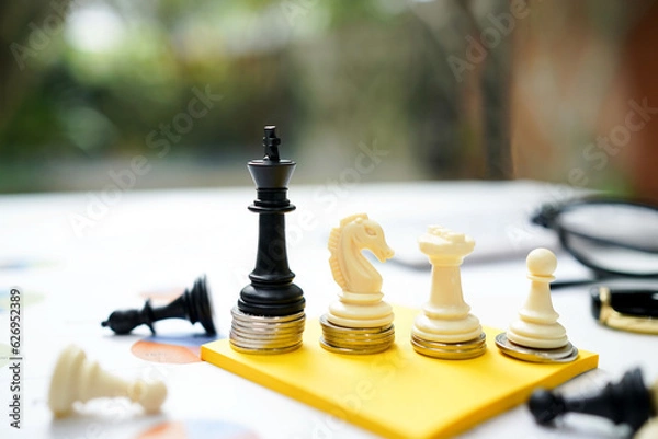 Fototapeta  The chess business game for investment, investor competition concept in the modern style. Chess with the coin and money and some plan for business investment on yellow paper