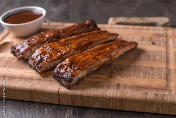 Obraz RIbs on a cutting board with BBQ sauce