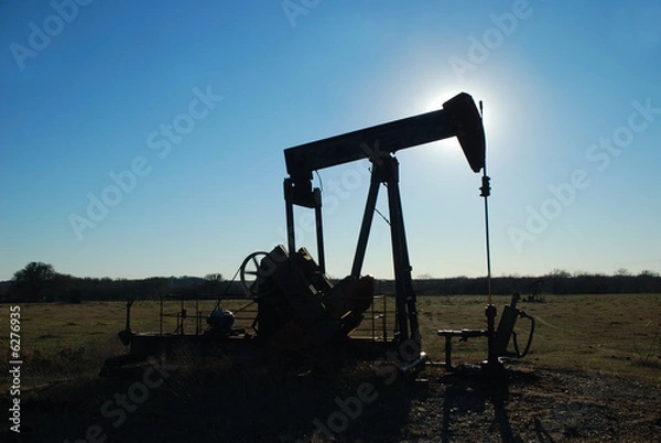 Obraz Silhouette pump jack backlight by the afternoon sun.