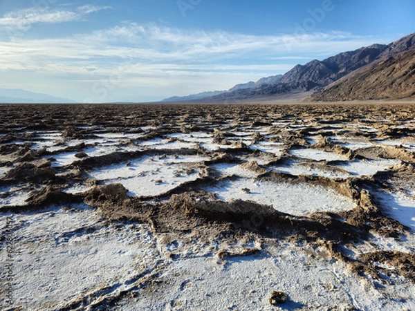 Fototapeta Desert landscape of Death Valley, Badwater Basin. Ancient seabed dried up, with hard rocks and craters filled with salt