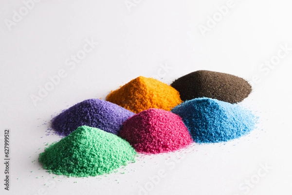 Fototapeta Close up of heaps of multi coloured sand and copy space on white background