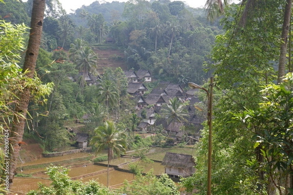 Obraz A traditional Indonesian village surrounded by mountains and rice fields called Kampung Naga. 