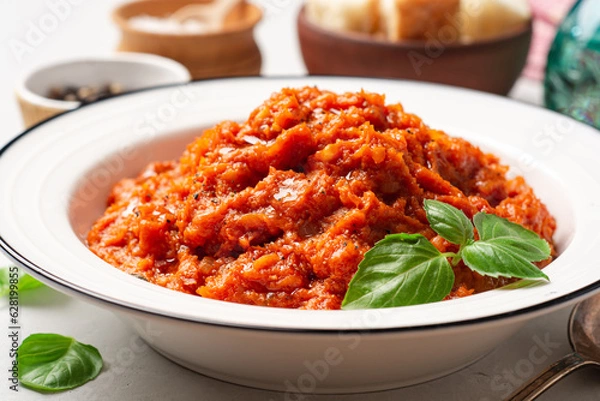 Fototapeta Pappa al Pomodoro. Tuscan bread soup with tomatoes, olive oil and basil in plate on concrete background. Traditional italian dish.