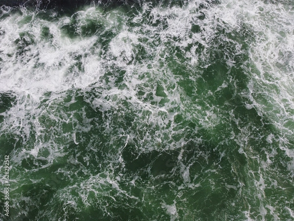 Fototapeta The texture of the waves of turquoise color of fast-flowing water in the river.