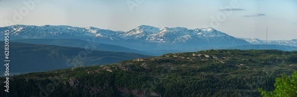 Fototapeta Panorama over nordic mountain peaks in Norway from a hike up Hauknestinden, Hauknes, Mo i Rana, Helgeland, Norway. Peaks in a fjord landscape, snow covered. Clear Norwegian summer skies. Wild Norway