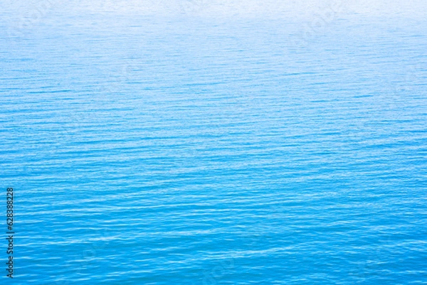 Fototapeta Abstract photo of Sun light reflecting or sparkling glitter on water of sea or ocean with beautiful sky blue light tone.