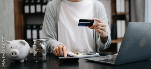 Fototapeta businesswoman hand using smart phone, tablet payments and holding credit card online shopping, omni channel, digital tablet docking keyboard computer at office in sun light.