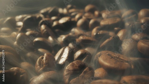 Fototapeta Slider shot of coffee beans during roasting. Dark roasted coffee beans with smoke. Smoke comes from fresh coffee seeds. Macro shot, 4K