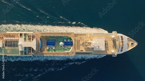 Fototapeta Aerial top down view of Huge cruise ship with football field and swimming pools. Flying over cruise ship in the sea