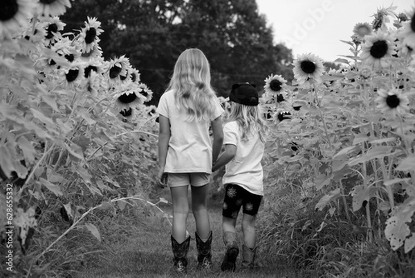 Obraz two children walking through sunflowers