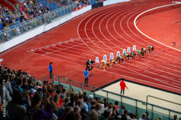 Fototapeta Female Sprinters at the start line of the 100 meters sprint race. Track and Field photo for Summer Game in Paris