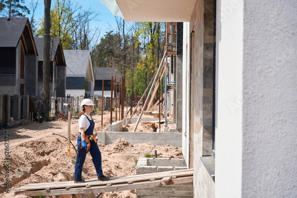 Obraz Woman building engineer holding electric screwdriver in hands