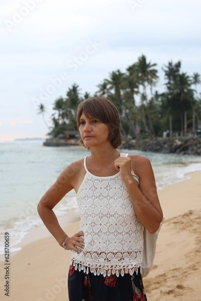 Obraz Happy young woman traveller on the tropical beach near the ocean in Sri Lanka.