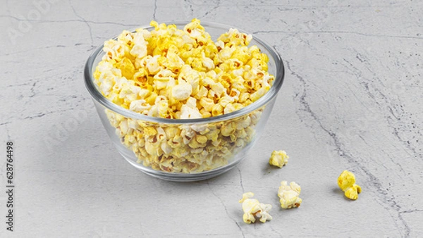 Fototapeta popcorn in a glass bowl on textured marble background with styling