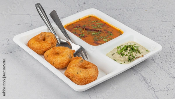 Fototapeta Vada / Medu vadai with sambar - Popular South Indian snack in white plate with chutney 